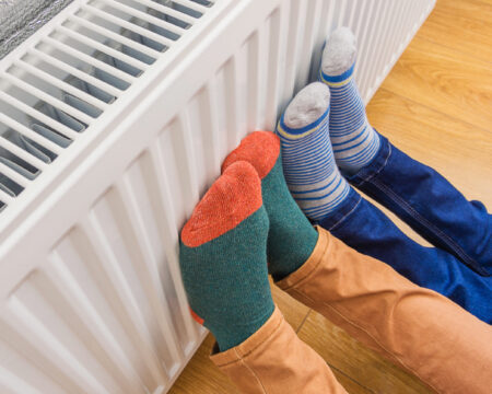 Füße in Bunten Socken werden an der Heizung gewährmt.