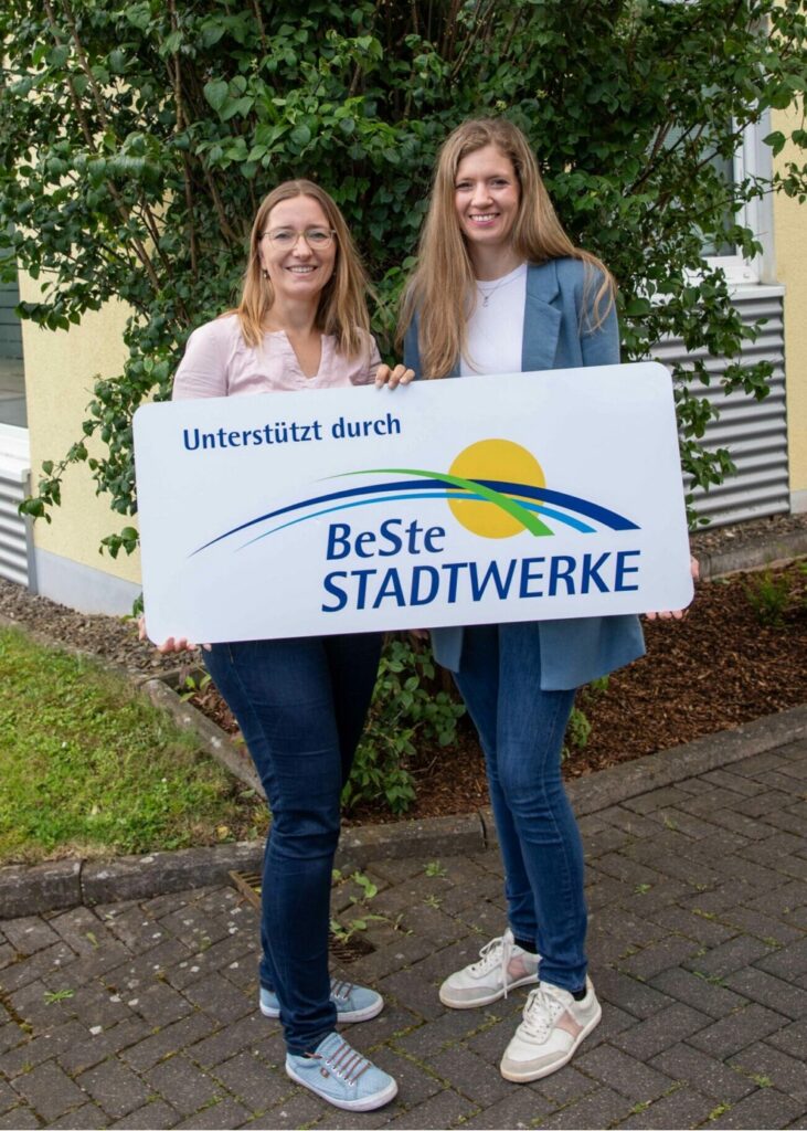 Foto von zwei Mitarbeiterinnen, die eine Auszeichnung in der Hand halten.