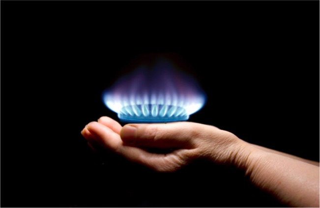 Eine Hand hält eine Gas Flamme in der Hand.