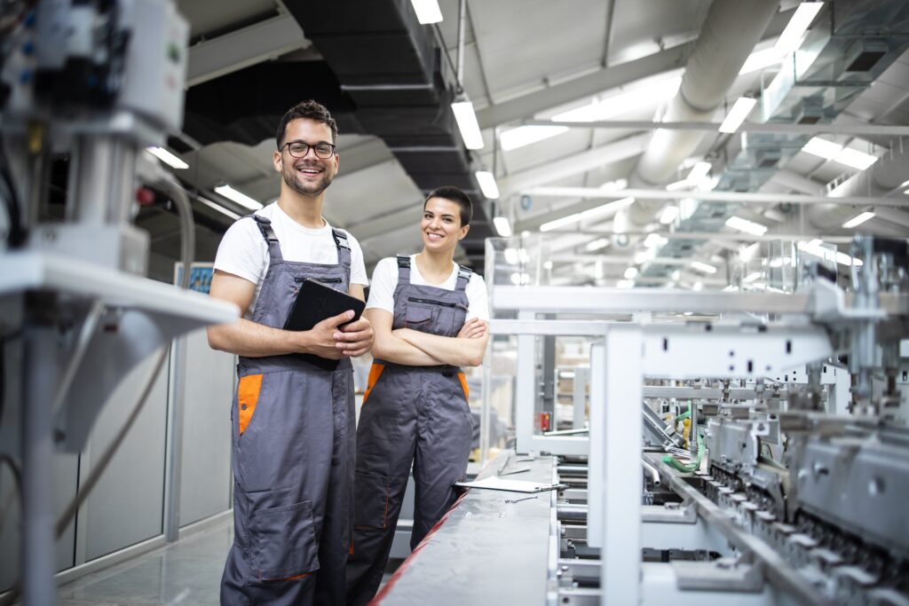 Eine Frau und ein Mann stehen in einer Industrie Halle.