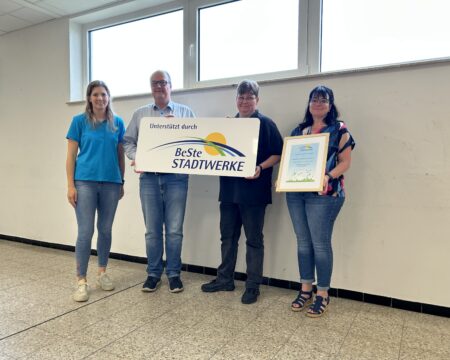Vier Personen stehen vor einer Wand mit neuen Fenstern.