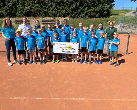 Eine Gruppe Kinder steht auf einem Tennisplatz