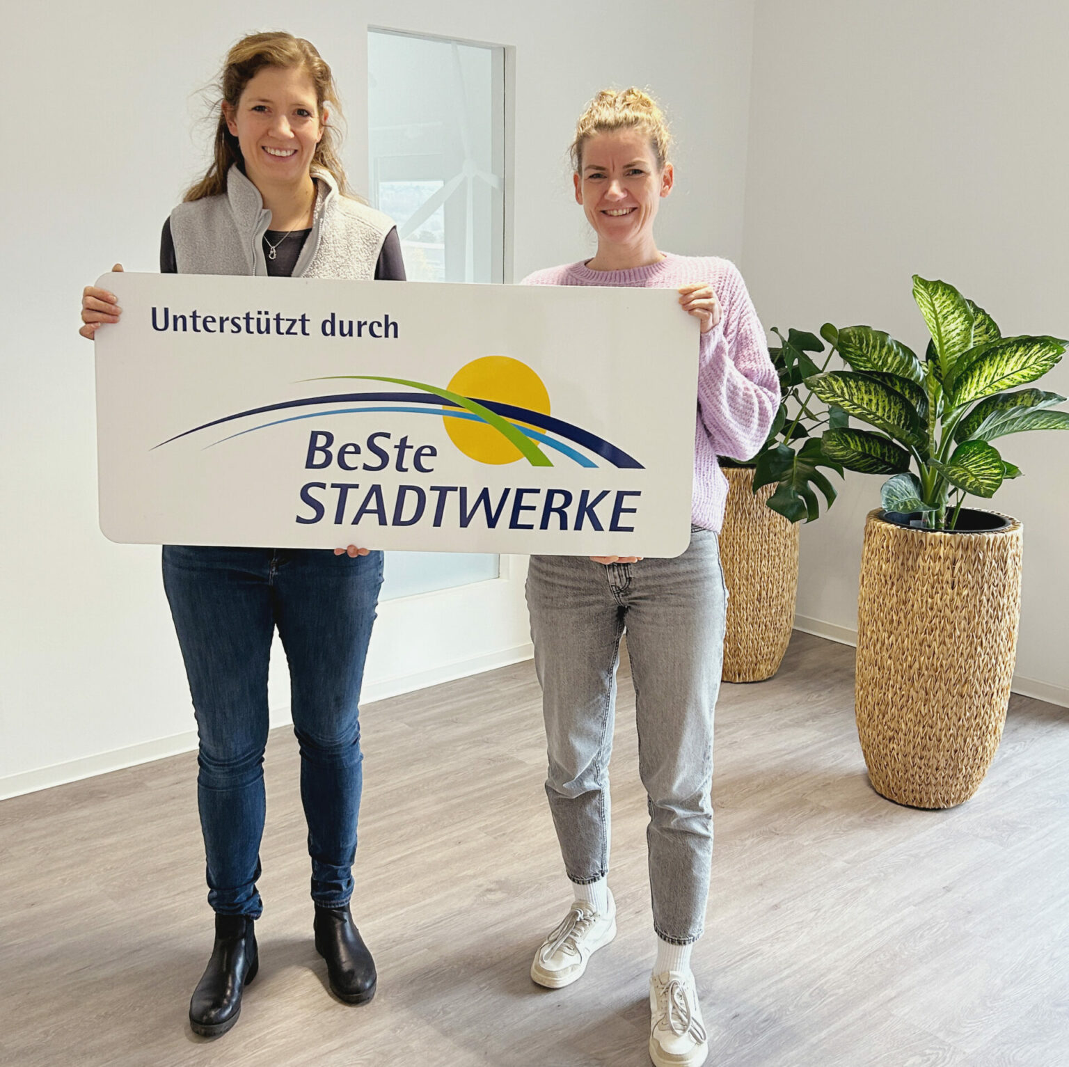 Zwei Frauen halten ein Schild in der Hand