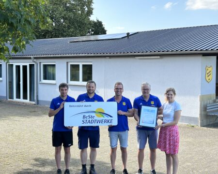 Fünf Personen stehen vor einem Vereinsgebäude